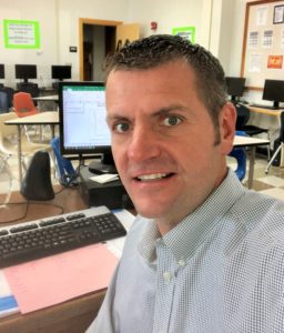 Headshot of teacher Klimkiewicz at a computer.
